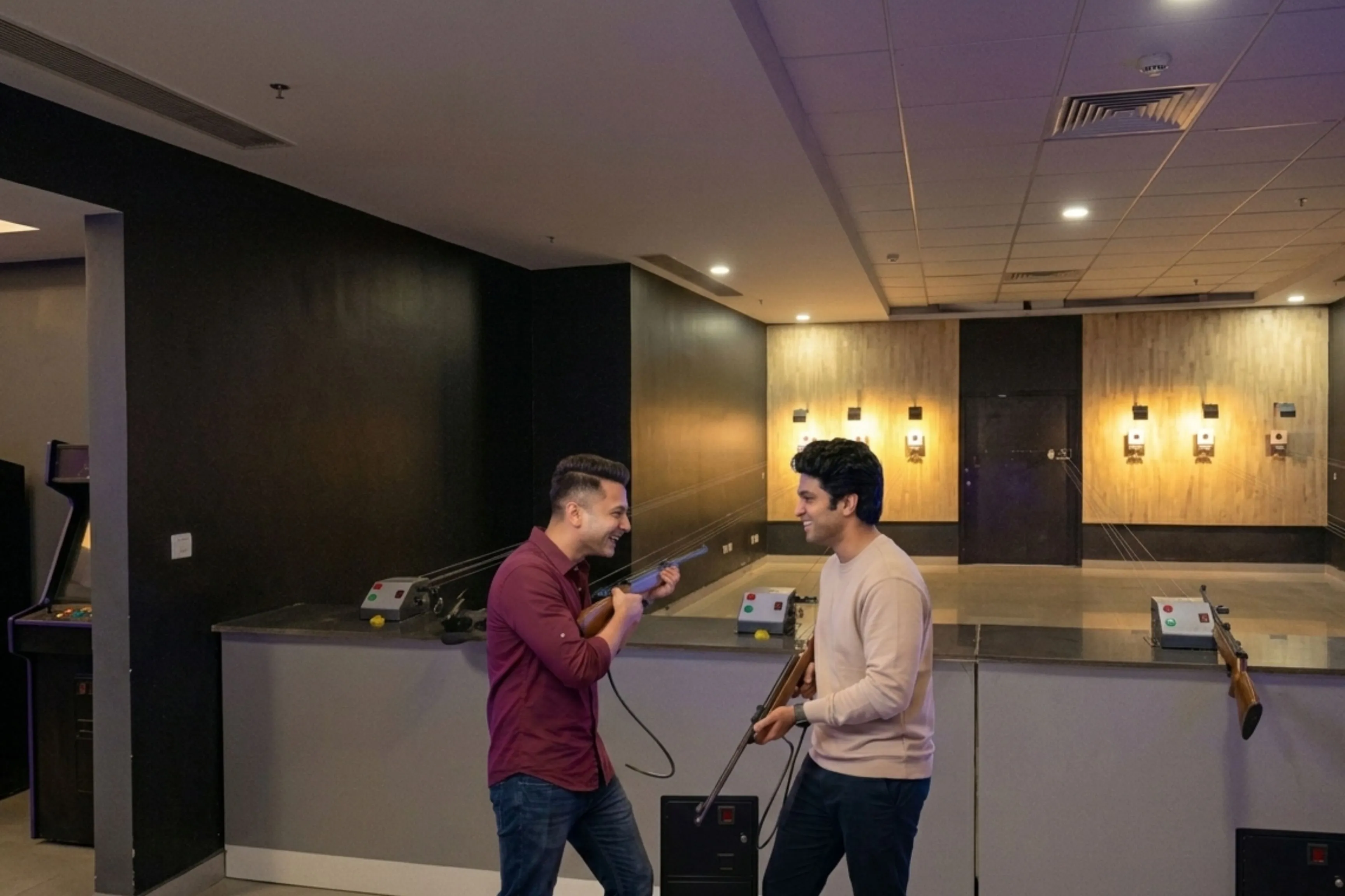 Two friends laughing together at the air gun shooting range at Game Xtreme