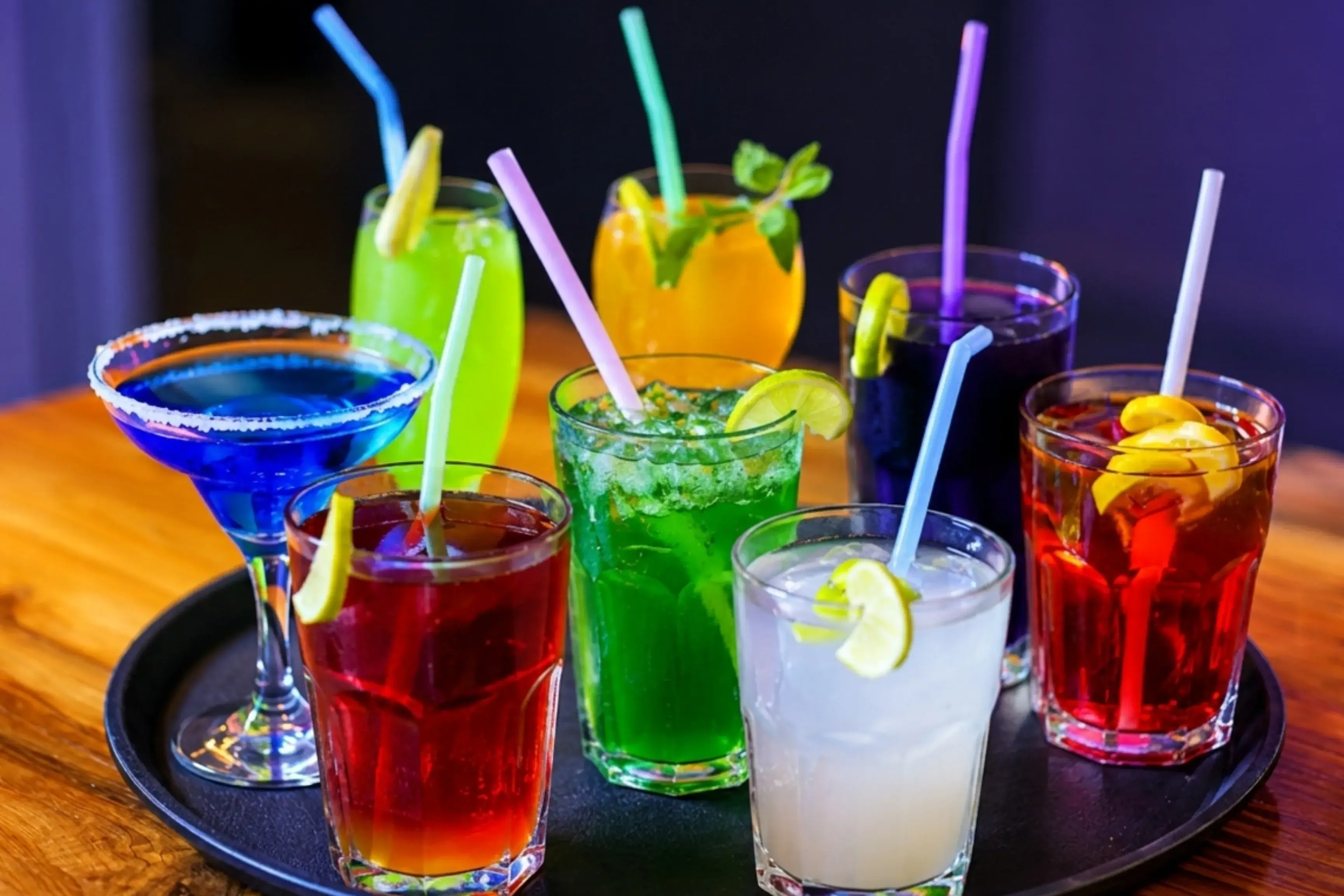 Nine colourful mocktails arranged on a round tray at Game Xtreme
