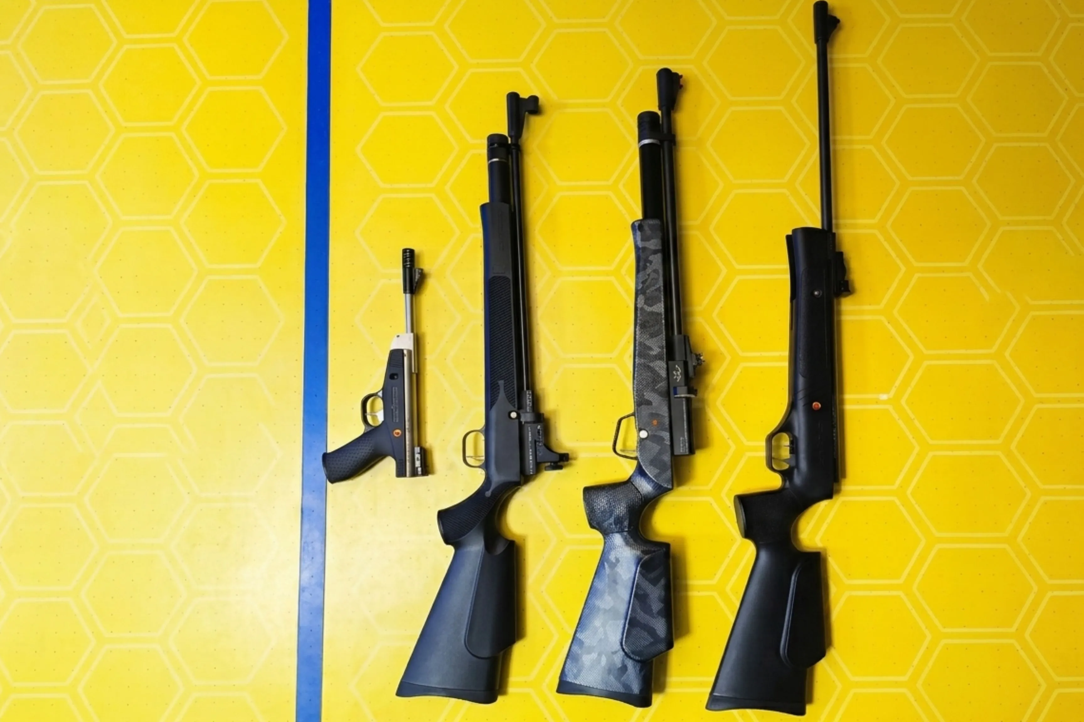 Four air guns laid out on table at Game Xtreme shooting range