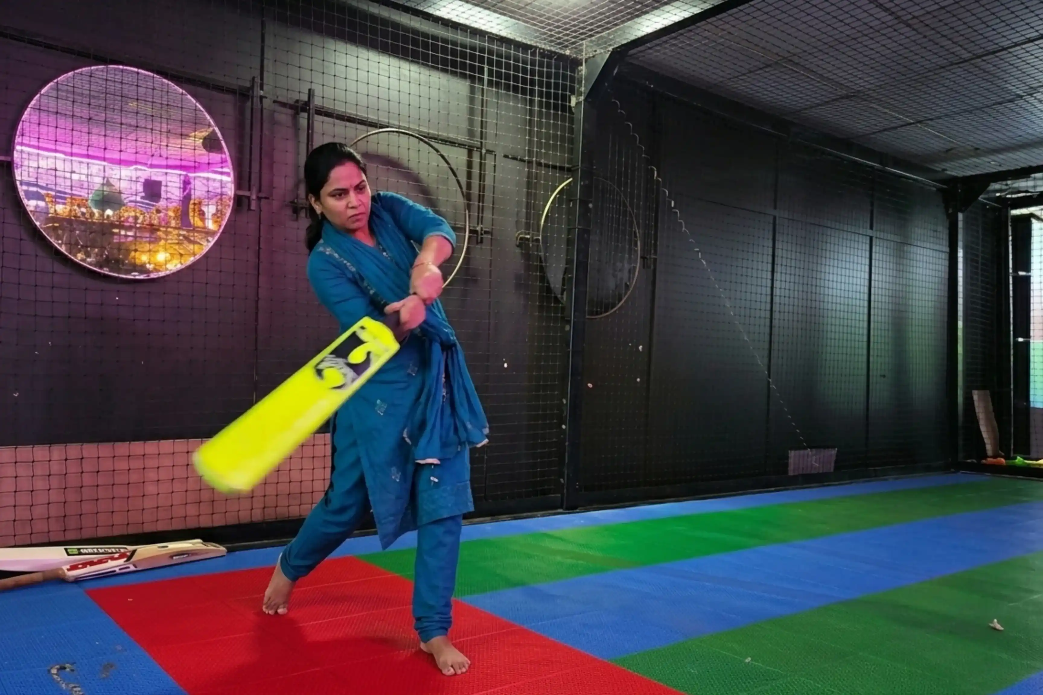Woman batting in indoor cricket simulator at Game Xtreme Hyderabad