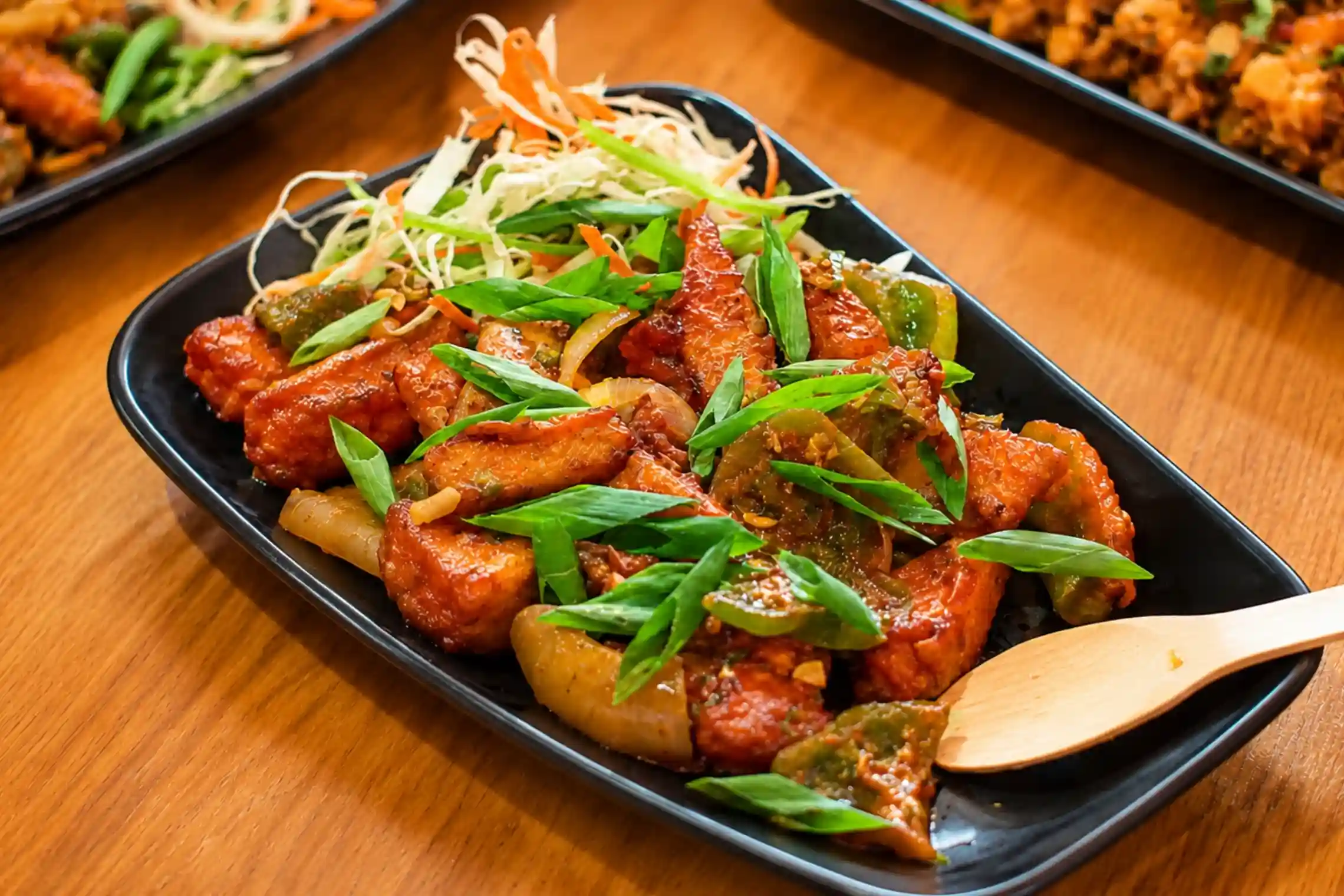 Sizzling chilli starter garnished with peppers and spring onions