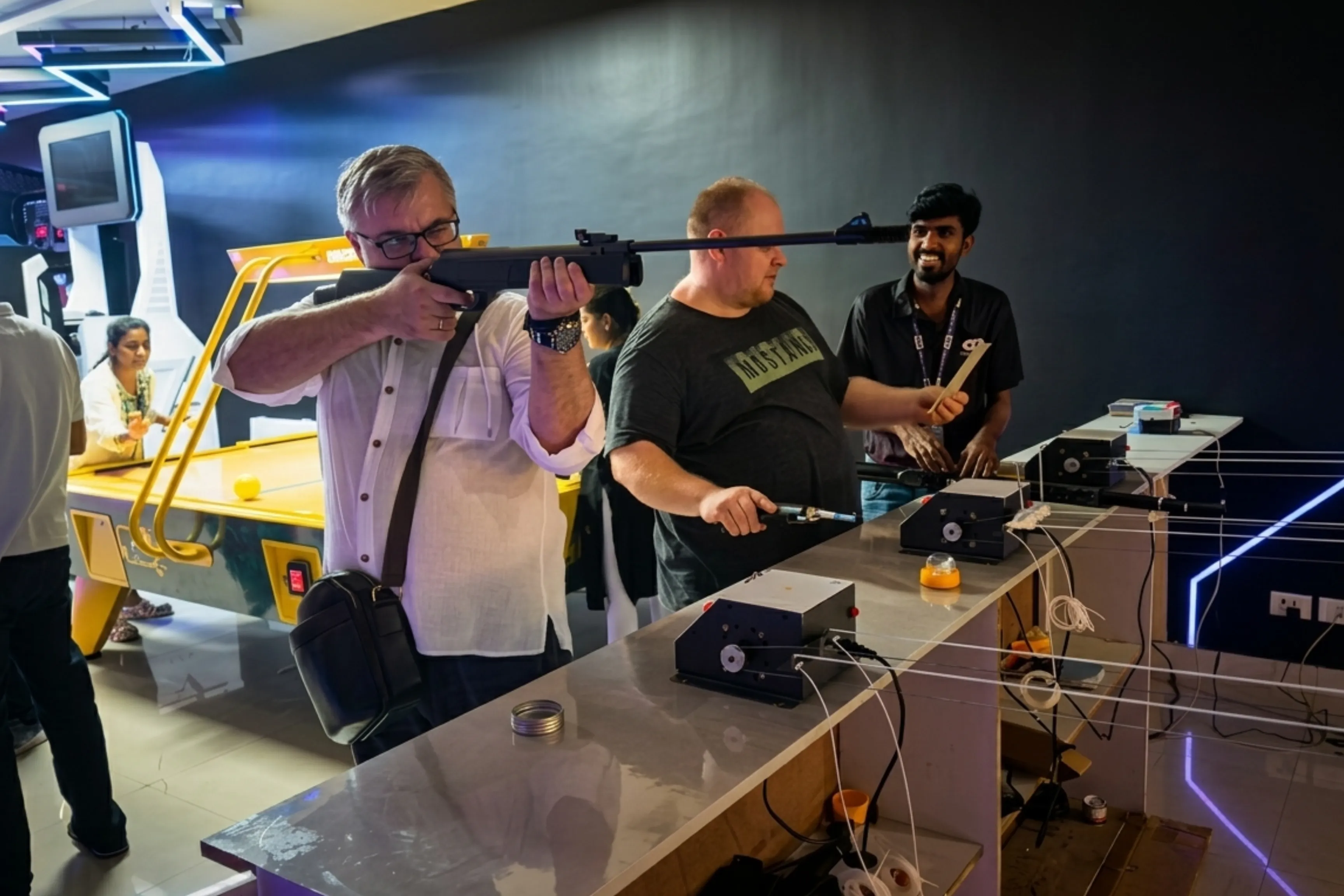 Player aiming air gun with Game Xtreme staff member supervising the session